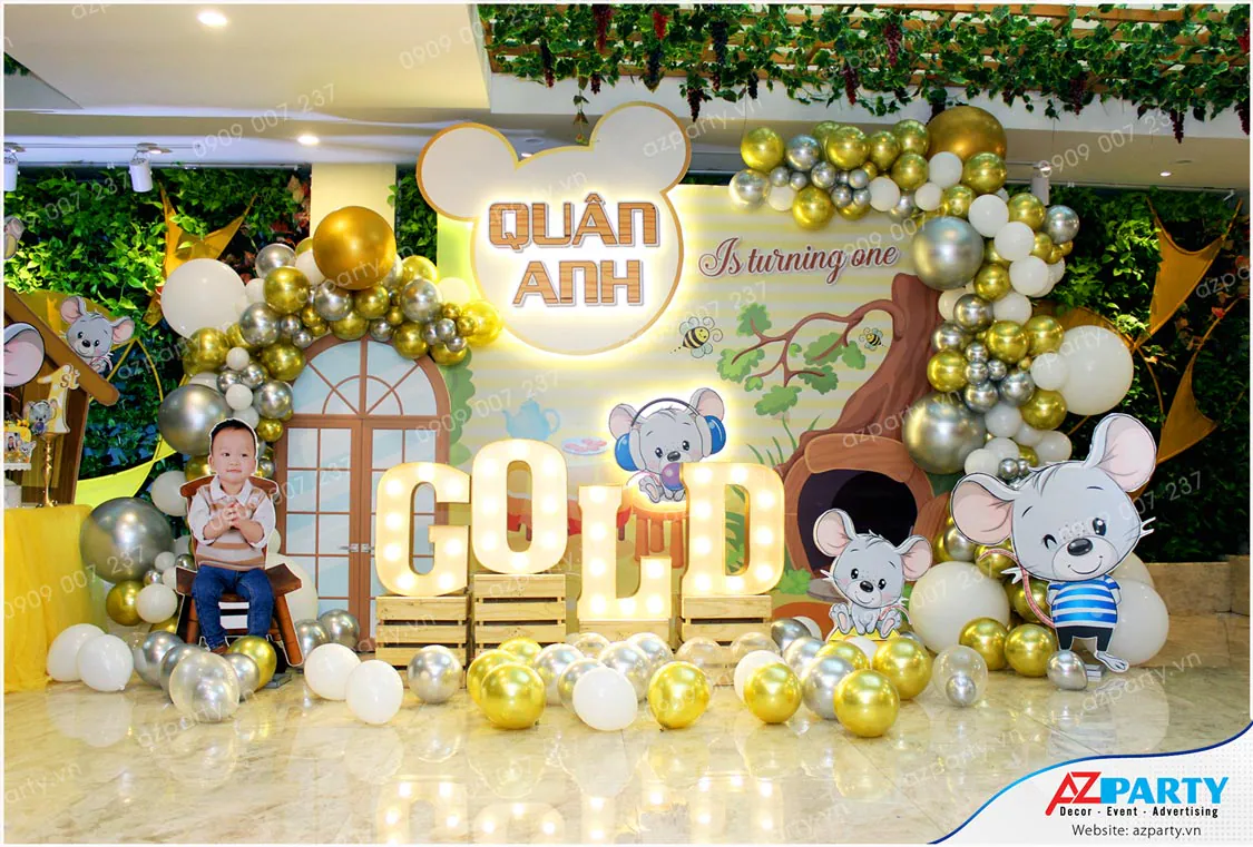 Trang trí thôi nôi bé Quân Anh (Gold) chủ đề chú chuột con dễ thương tinh nghịch với bóng bay tông vàng kim, bạc và bộ chữ tên bé rực rỡ.