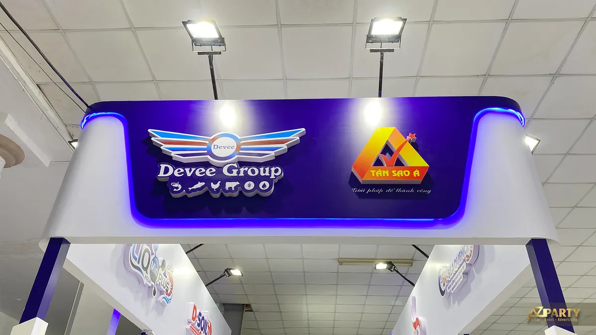 Bảng hiệu Deeve Group và Tân Sao Á nhìn từ dưới lên với đèn chiếu sáng trên cao