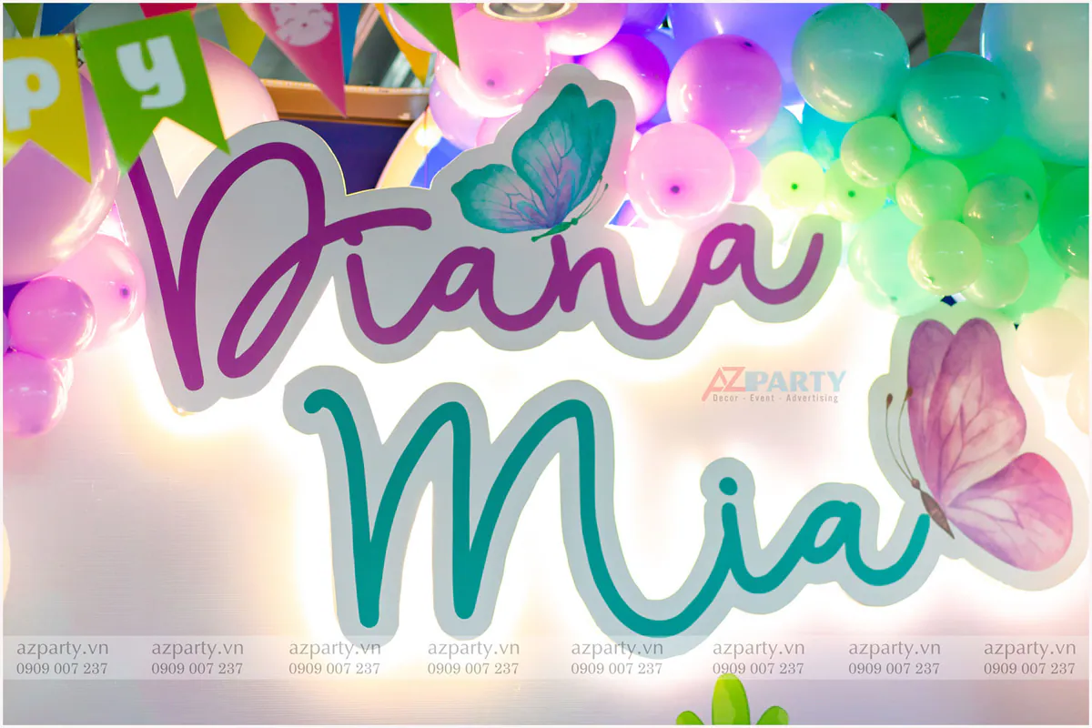Cận cảnh bảng tên đèn LED phát sáng của hai bé Diana & Mia được trang trí nổi bật trên backdrop tiệc sinh nhật.