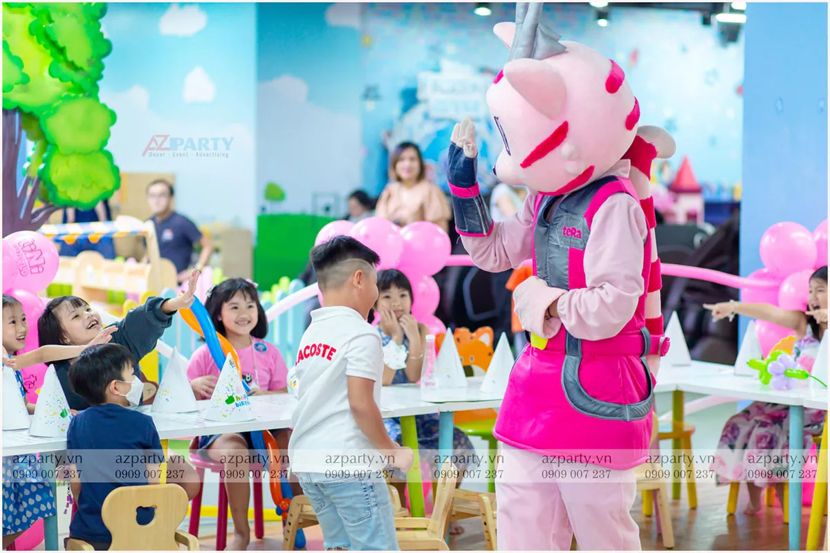 Mascot khổng lồ Tera từ tiiniWorld giao lưu và đập tay (high-five) cùng các bé tại bàn tiệc sinh nhật.