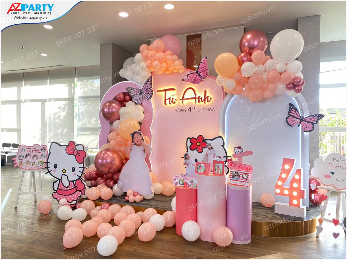 Không gian sân khấu chính trang hoàng rực rỡ với bóng bay và standee Hello Kitty trong tiệc sinh nhật bé Tú Anh.