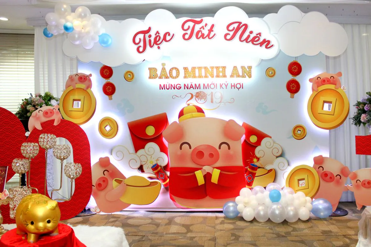 backdrop tiệc tất niên Công Ty Bảo Minh An, nổi bật với sắc đó và vàng của hú heo mập cùng những đồng tiền vàng may mắn