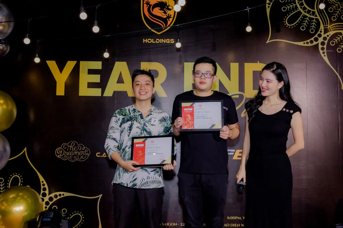 Hai nhân viên nam C.A.M Holdings nhận giải thưởng trên sân khấu tiệc tất niên