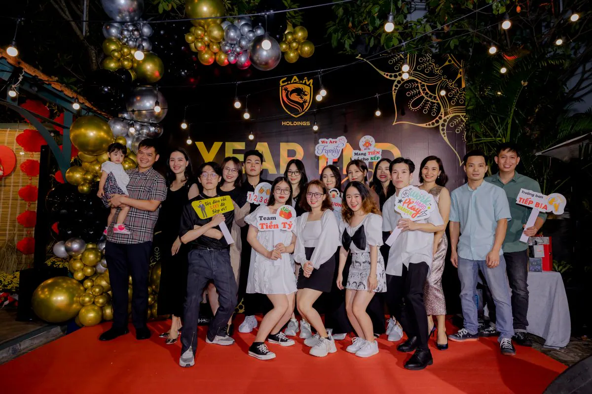 Các nhân viên nam và nữ C.A.M Holdings check-in chụp hình trên sân khấu tiệc tất niên