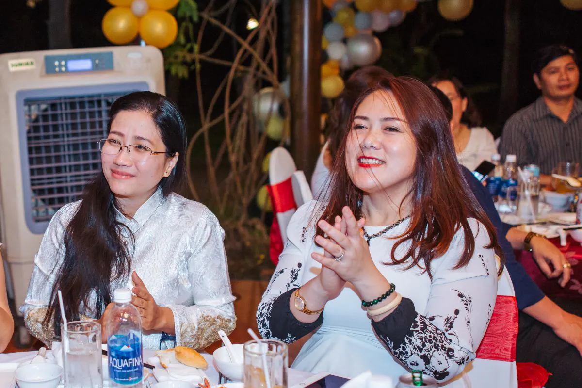 Khách mời tươi cười thưởng thức chương trình tại bàn tiệc