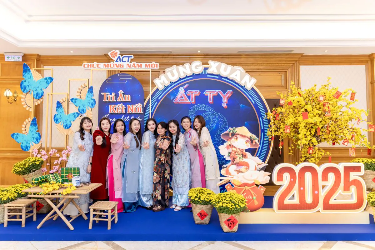 Tập thể nữ nhân viên ACT duyên dáng trong tà áo dài truyền thống chụp ảnh lưu niệm tại photobooth tất niên của công ty.