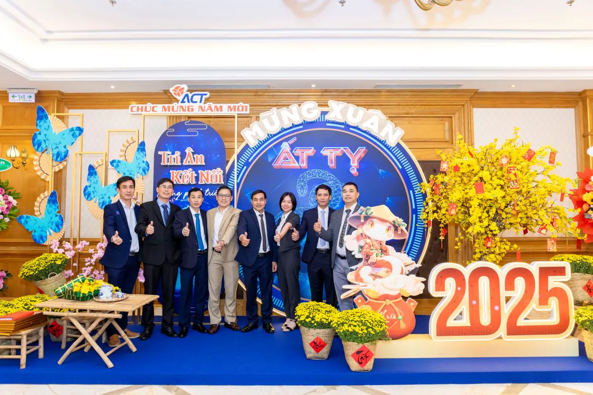 Ban điều hành và các nhân viên nam thanh lịch trong trang phục vest chụp hình lưu niệm cùng nhau tại khu vực check-in.