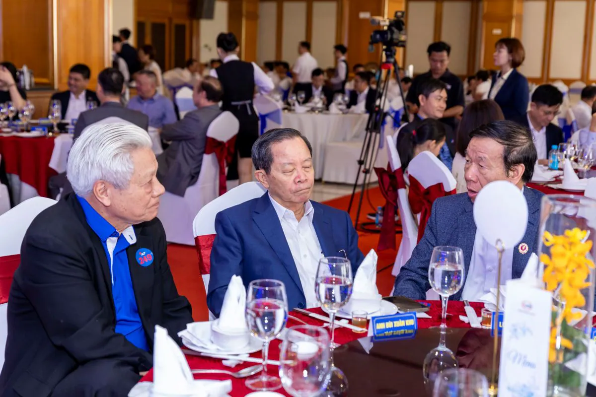 Các đại biểu cao niên và cổ đông trò chuyện thân tình bên bàn tiệc trong không khí ấm cúng của buổi gặp mặt tất niên.