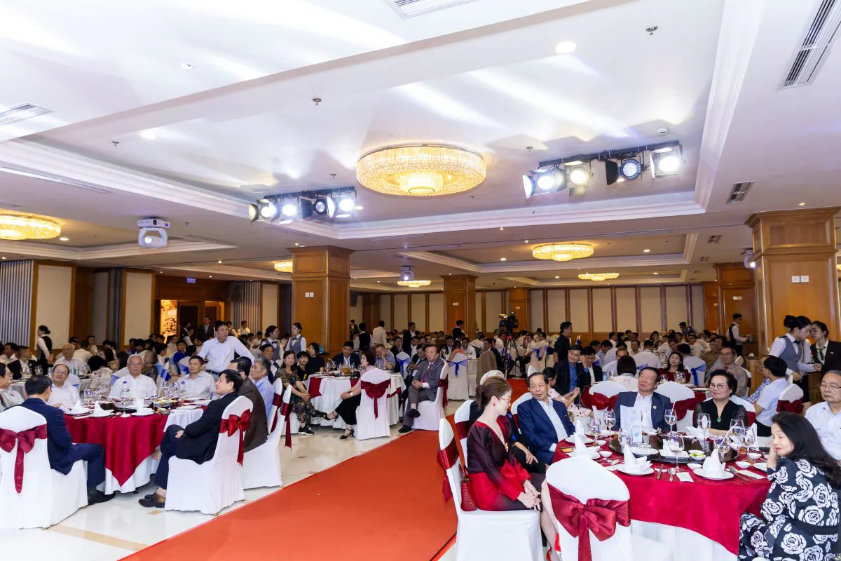 Toàn cảnh không gian khán phòng tiệc tất niên ACT sang trọng với các bàn tiệc tròn được xếp đặt chỉnh chu dọc lối đi trải thảm đỏ.