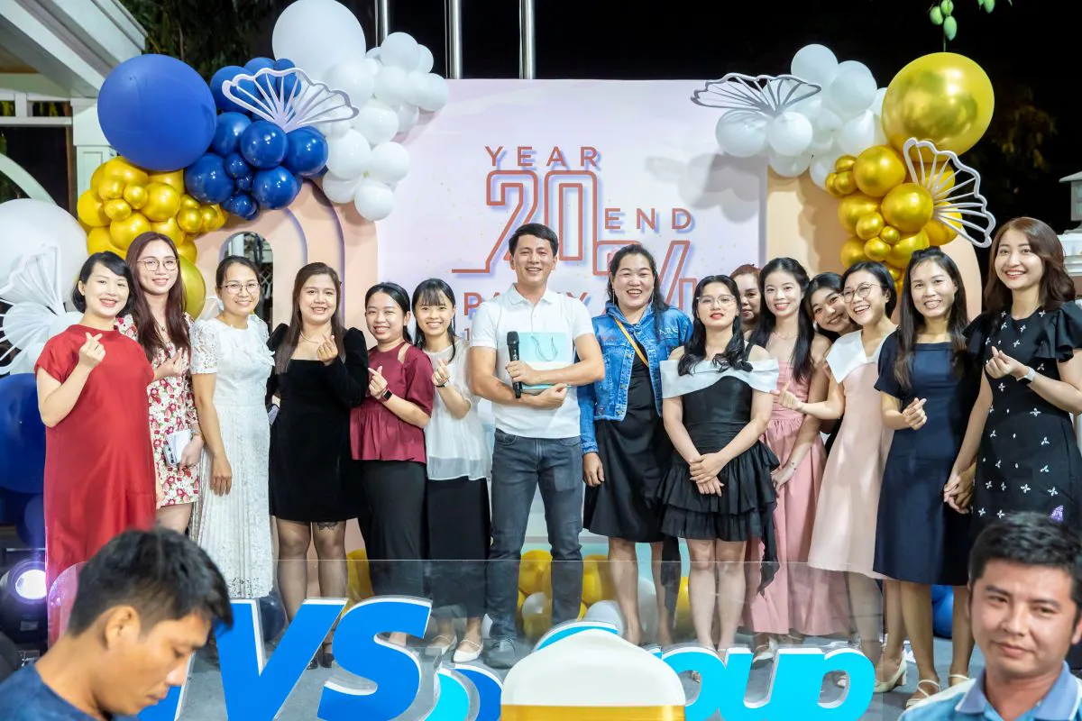 Nhóm nữ nhân viên rạng rỡ chụp hình lưu niệm cùng nam nhân viên nhận quà may mắn trên sân khấu sự kiện tất niên HVS Group.