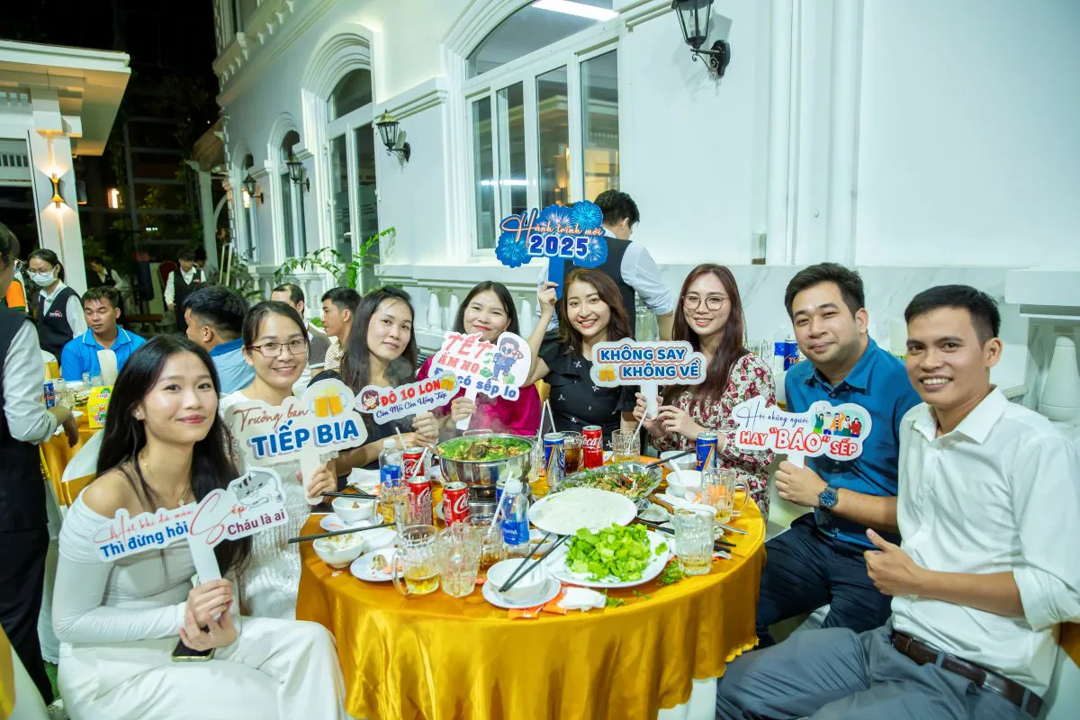 Nhóm khách mời rạng rỡ nâng các bảng hashtag check-in hài hước tại bàn tiệc tất niên của HVS Group.