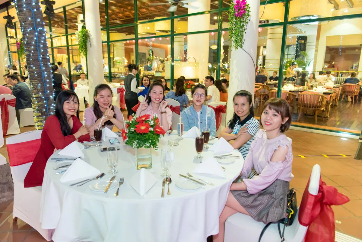 nhóm nhân viên nữ chụp hình tại bàn tiệc