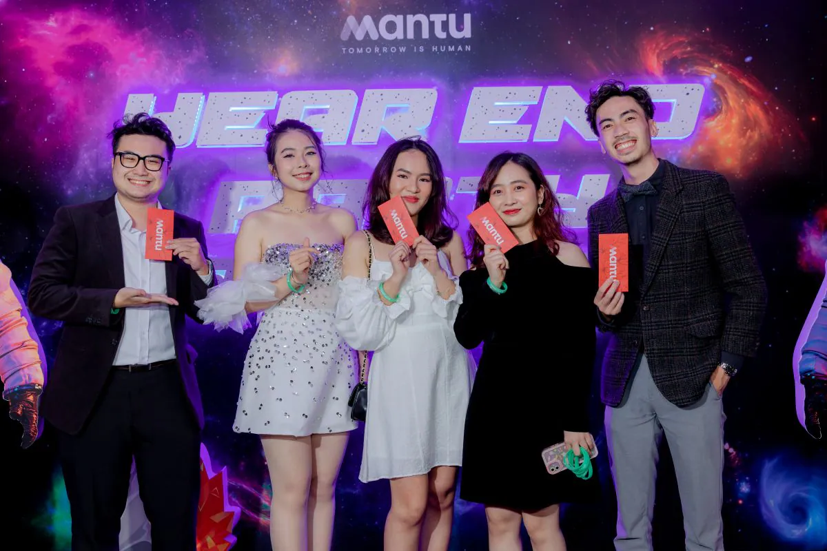 Nhóm nhân viên Mantu chụp hình kỷ niệm tại photobooth, trên tay cầm những lá thăm may mắn