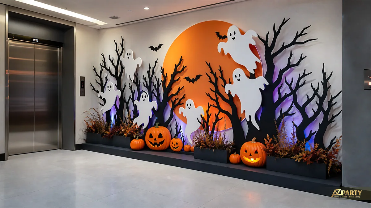 Mảng trang trí Halloween bên thang máy với trăng cam, cây đen, bóng ma và bí ngô