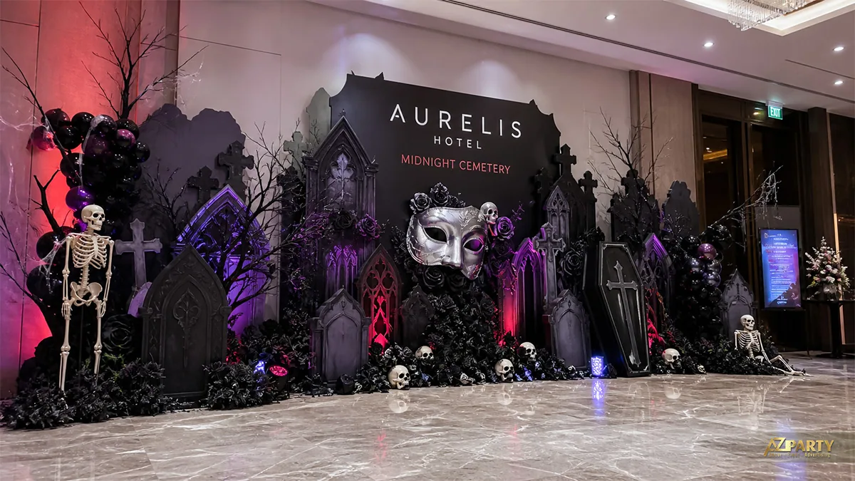 Tiểu cảnh nghĩa địa Halloween tại khách sạn với mặt nạ bạc, bộ xương, bia mộ và hoa đen