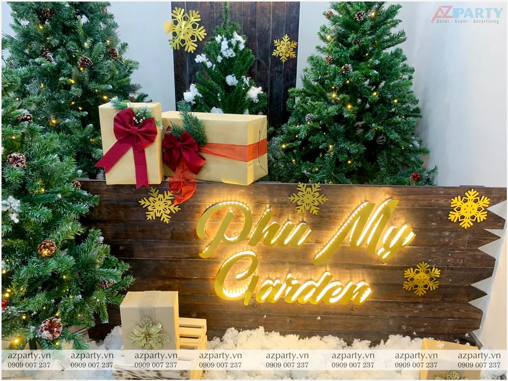 Cận cảnh bảng gỗ trang trí Noel chữ LED Phu My Garden ấm áp kết hợp hộp quà bằng giấy xi măng thắt nơ đỏ và nhánh thông xanh đậm chất cổ điển
