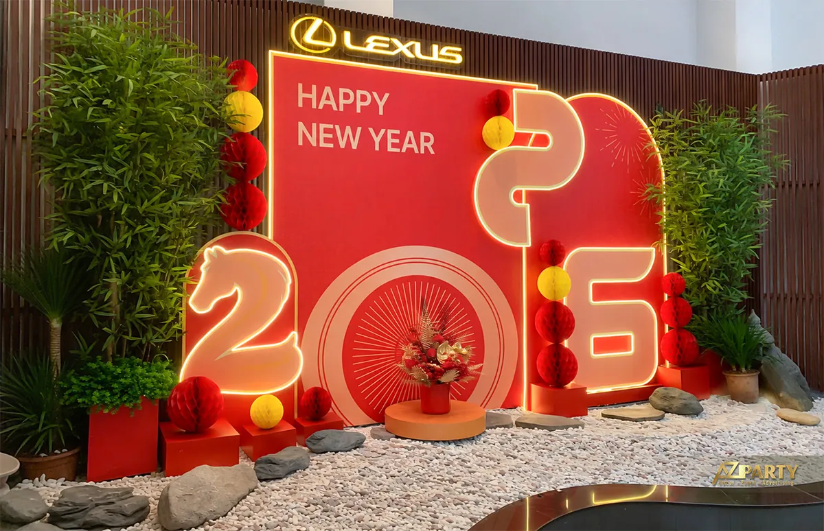 Góc nghiêng bên trái của tiểu cảnh Tết Lexus với mảng đỏ, số 2026 phát sáng và cây xanh