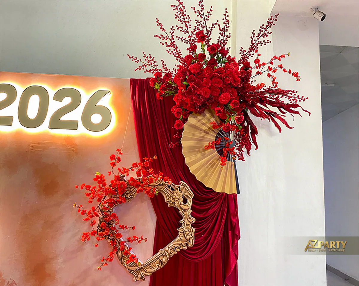 Chi tiết trang trí Tết 2026 với hoa đỏ, quạt giấy, khung trang trí cổ điển và rèm vải đỏ sang trọng