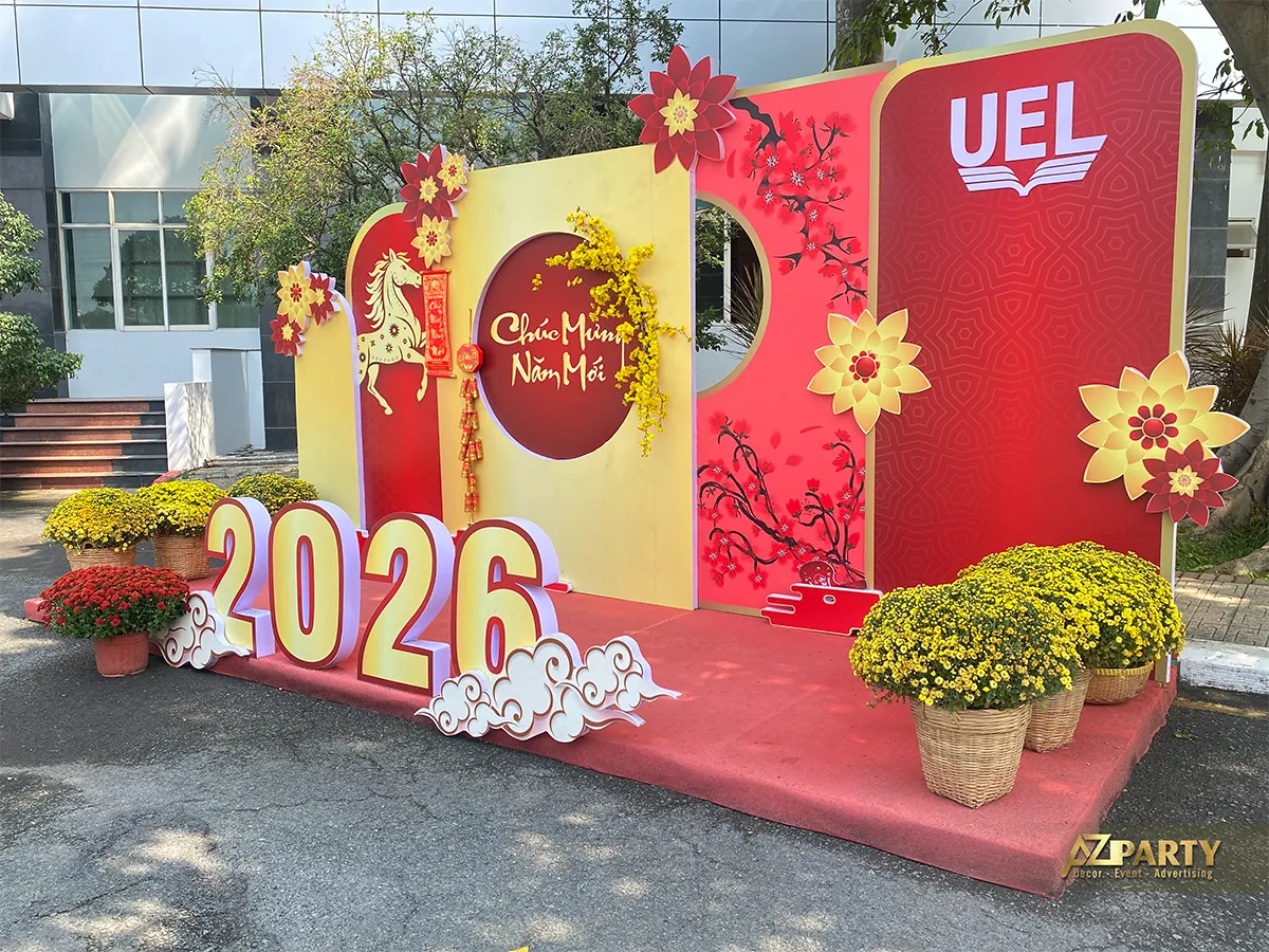 Góc nhìn bên phải làm nổi bật logo UEL, hoa đào và lời chúc mừng năm mới