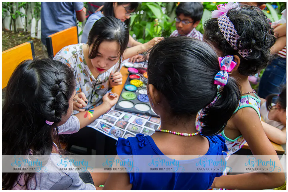 Nghệ nhân face painting đang tỉ mỉ vẽ hình nghệ thuật màu sắc lên tay cho các bé thiếu nhi tại sự kiện Bosch