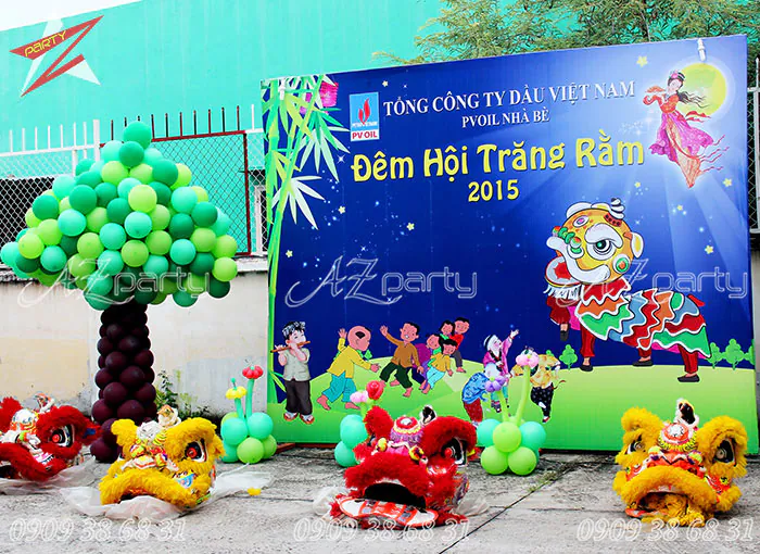 Trang trí backdrop Đêm Hội Trăng Rằm 2019 của PVOil Nhà Bè với cổng bong bóng hình cây xanh và các đầu lân đặt trước sân khấu.