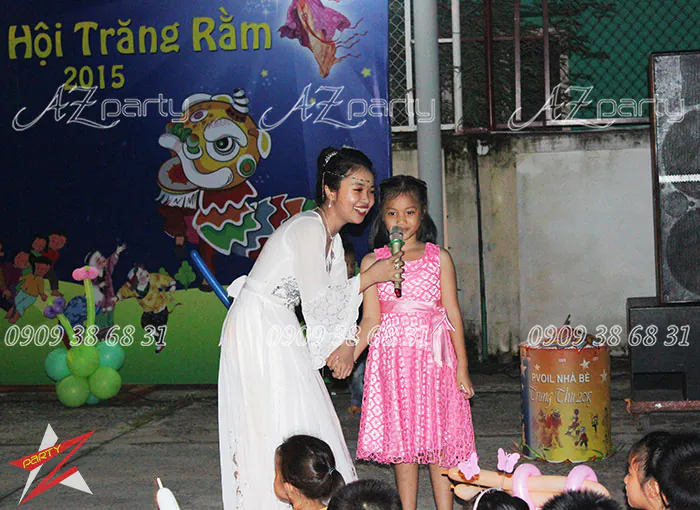 Chị Hằng phỏng vấn và cổ vũ một bé gái hát giao lưu văn nghệ trên sân khấu sự kiện Trung thu PVOil Nhà Bè.
