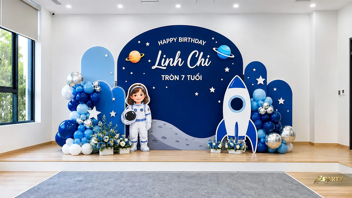 Backdrop sinh nhật tại trường cho Linh Chi tròn 7 tuổi, chủ đề phi hành gia, tên lửa và vũ trụ xanh.