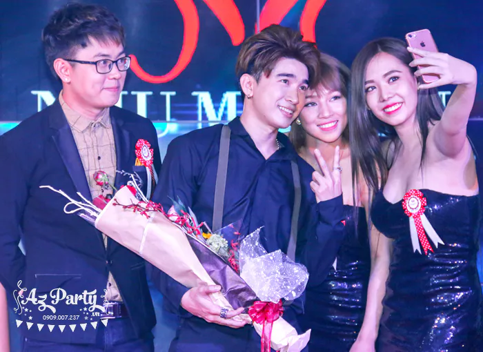 Nam ca sĩ vui vẻ selfie lưu niệm cùng các khách mời và người mẫu PG tại lễ kỷ niệm sinh nhật công ty.