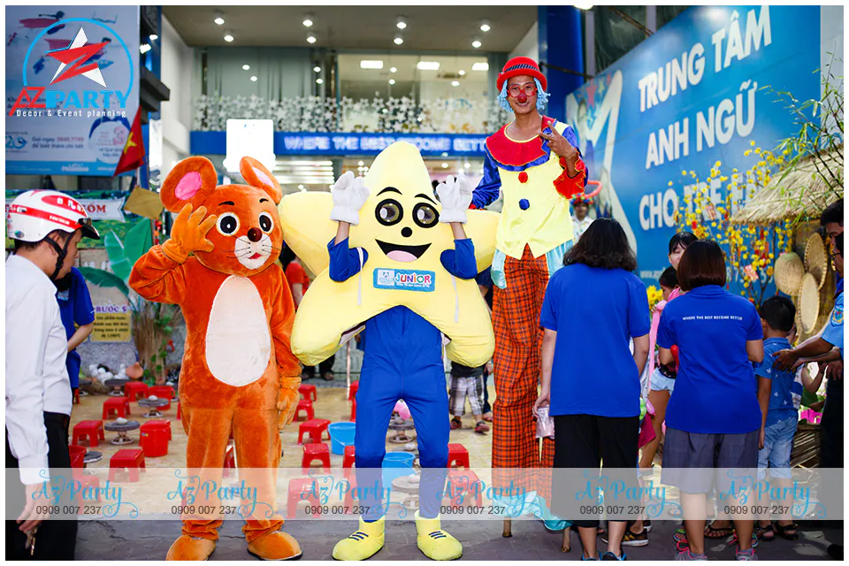 Mascot chuột cam sao vàng Apollo Junior và chú hề đi cà kheo cao lớn đứng chào đón ba mẹ và các bé học viên tham gia sự kiện