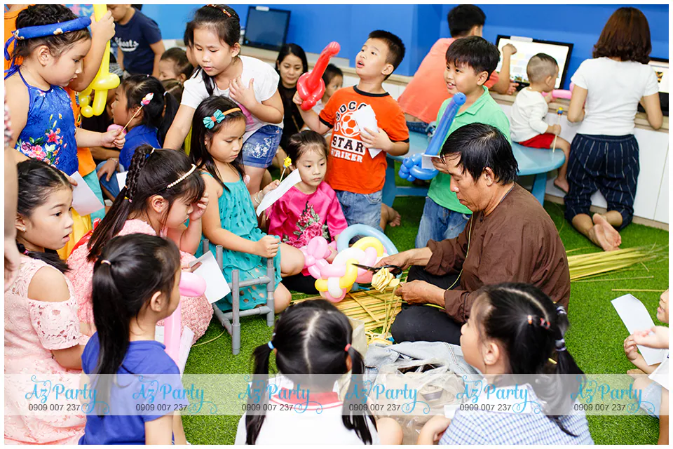 Nghệ nhân làm cào cào tre hướng dẫn tận tình cách gấp cào cào và xếp hình lá dừa lá tre cho các bé học viên tại Apollo English