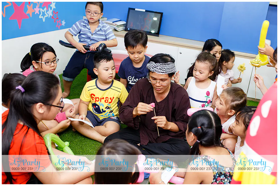 Nghệ nhân nặn tò he bằng bột màu truyền thống biểu diễn cho các em nhỏ học viên vây quanh chăm chú theo dõi tại Apollo English