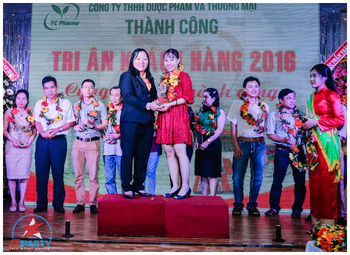 Đại diện TC Pharma trao kỷ niệm chương vinh danh và đeo vòng hoa chúc mừng các đối tác nhà thuốc xuất sắc.