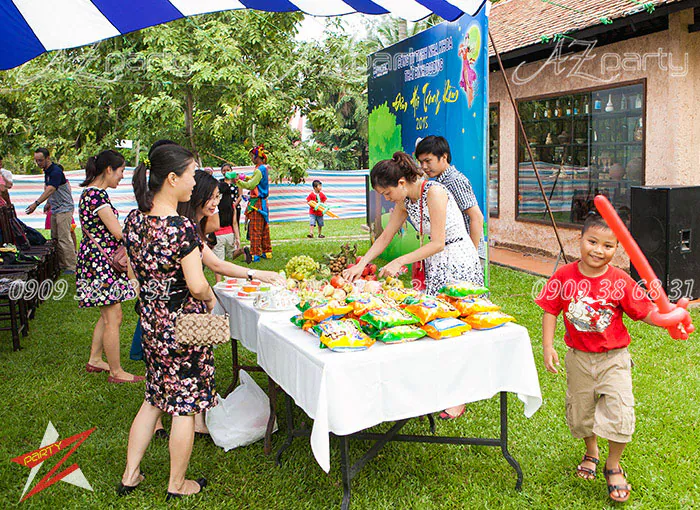 Bàn phá cỗ Trung thu bày biện nhiều bánh kẹo và hoa quả đầy màu sắc tại sự kiện.