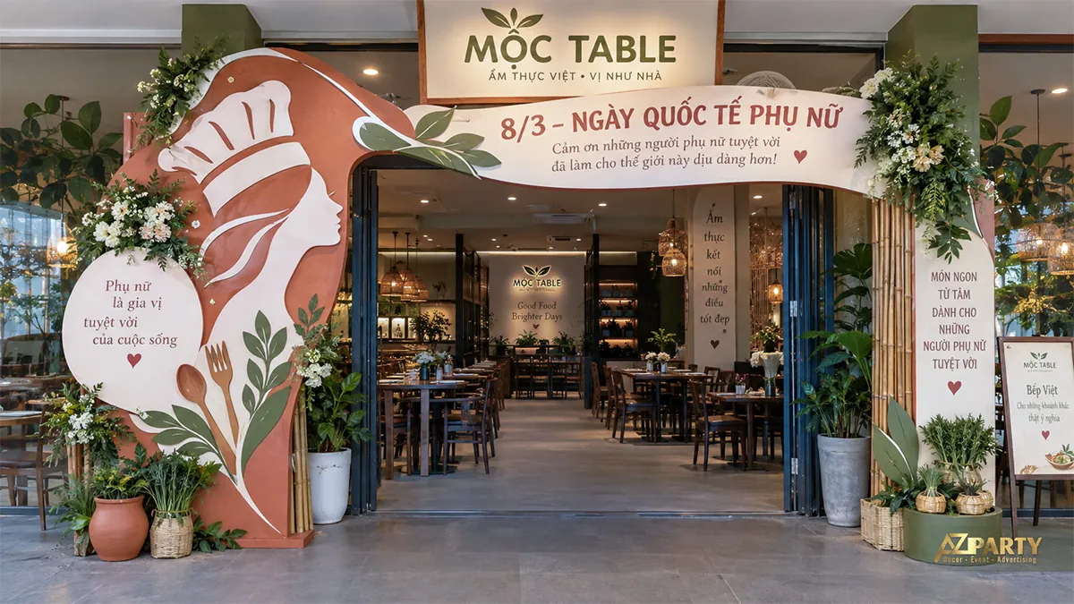 Cổng nhà hàng phối hình nữ đầu bếp, nan tre và hoa trắng xanh