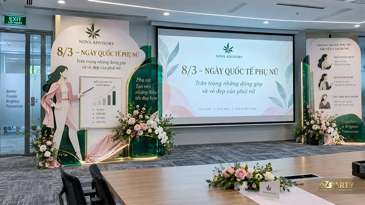 Phòng họp trang trí hai bên màn chiếu với hoa, hình người thuyết trình và mảng xanh hồng