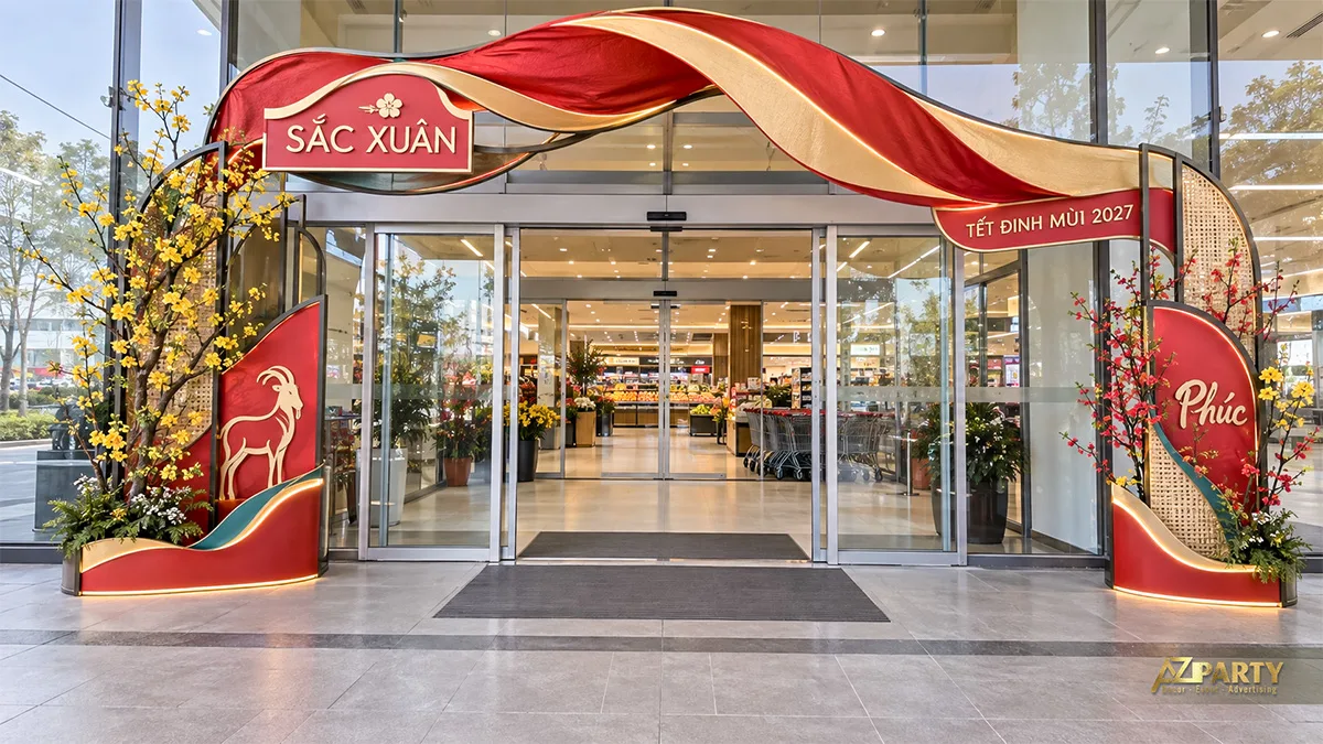Mái cổng uốn lượn đỏ vàng, hoa mai và mảng trang trí trước siêu thị