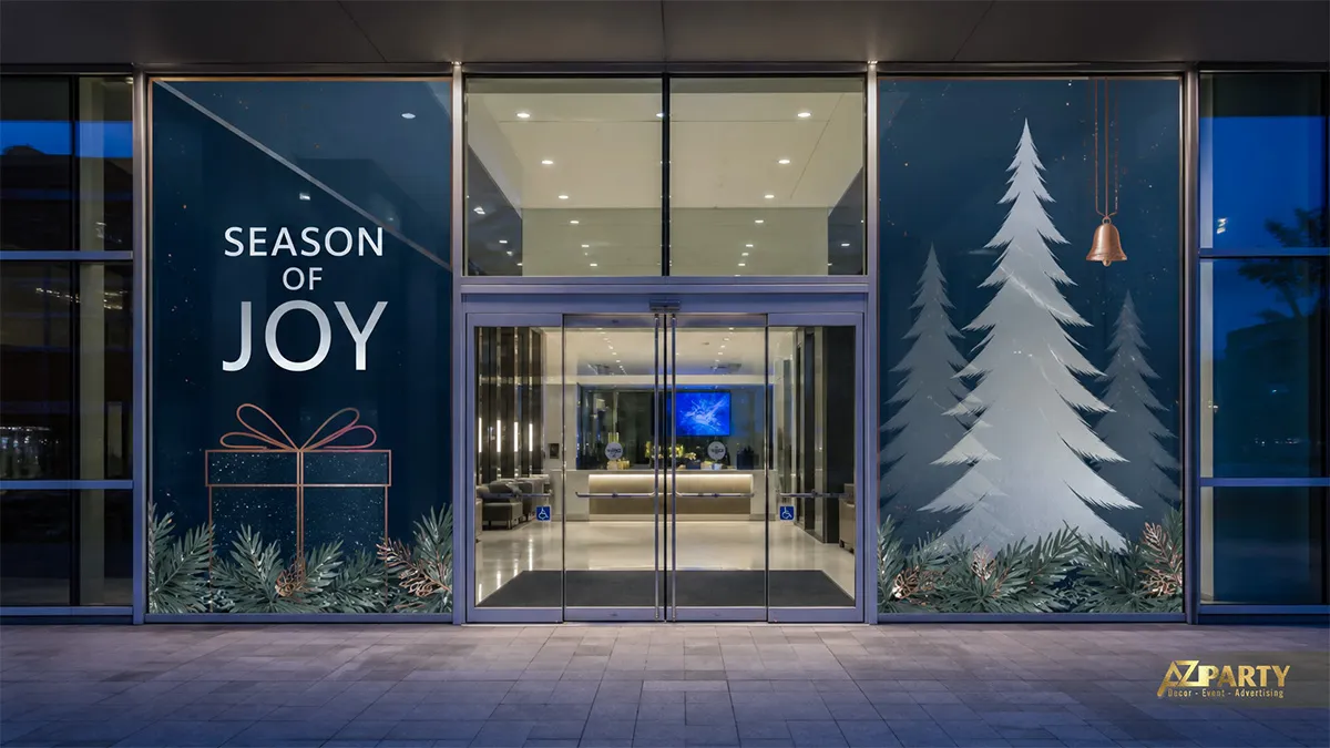 Mặt kính văn phòng buổi tối với decal cây thông trắng, chuông vàng và chữ Season of Joy