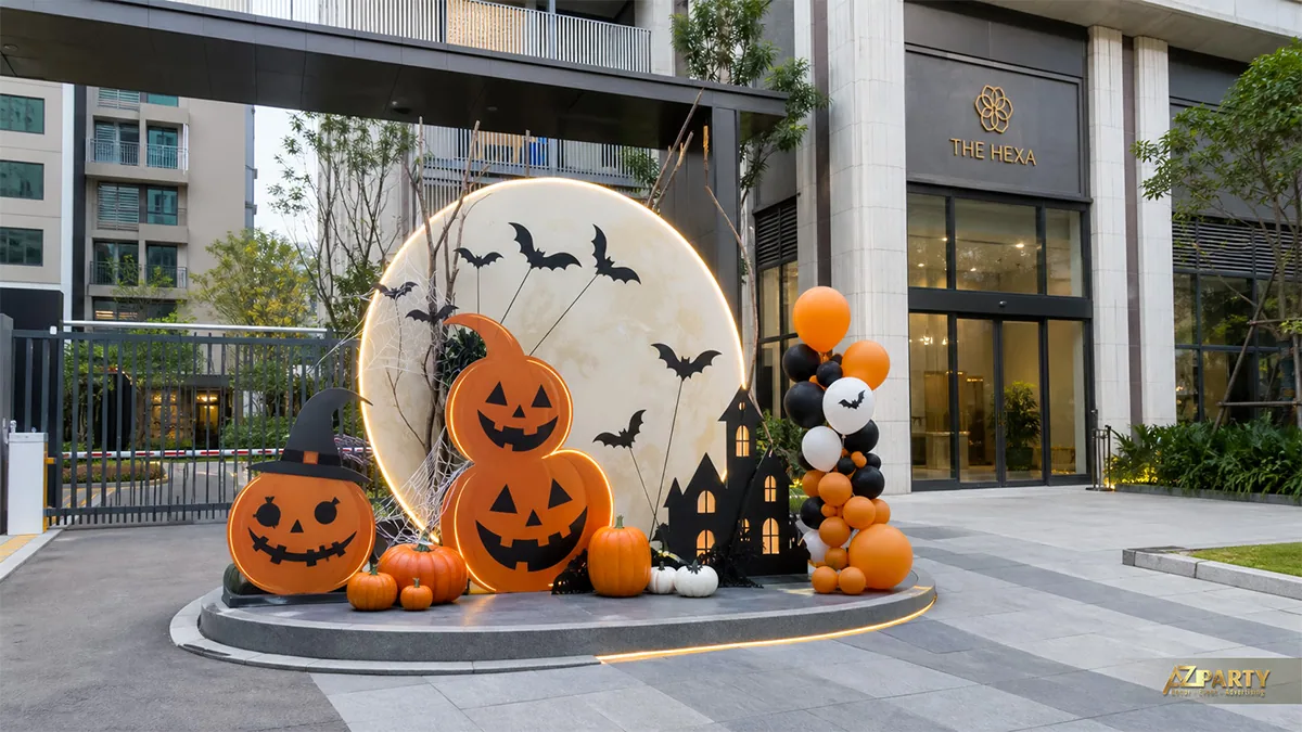 Tiểu cảnh Halloween ngoài sảnh chung cư với trăng tròn, ba bí ngô và cụm bóng cam đen