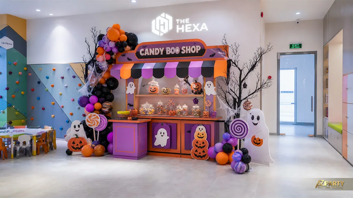 Quầy kẹo Halloween trong phòng sinh hoạt trẻ em với bóng tím cam, ma trắng và kẹo sắc màu