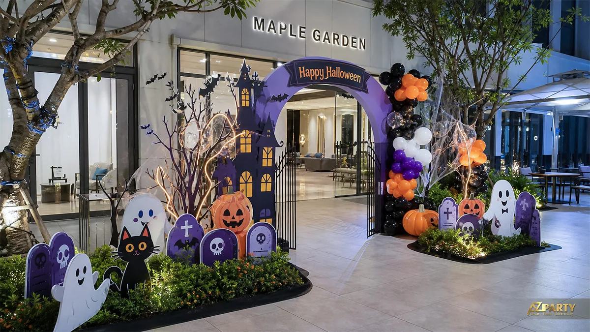 Cổng chào Halloween tím trước sảnh chung cư với lâu đài, bia mộ, bí ngô và bóng bay