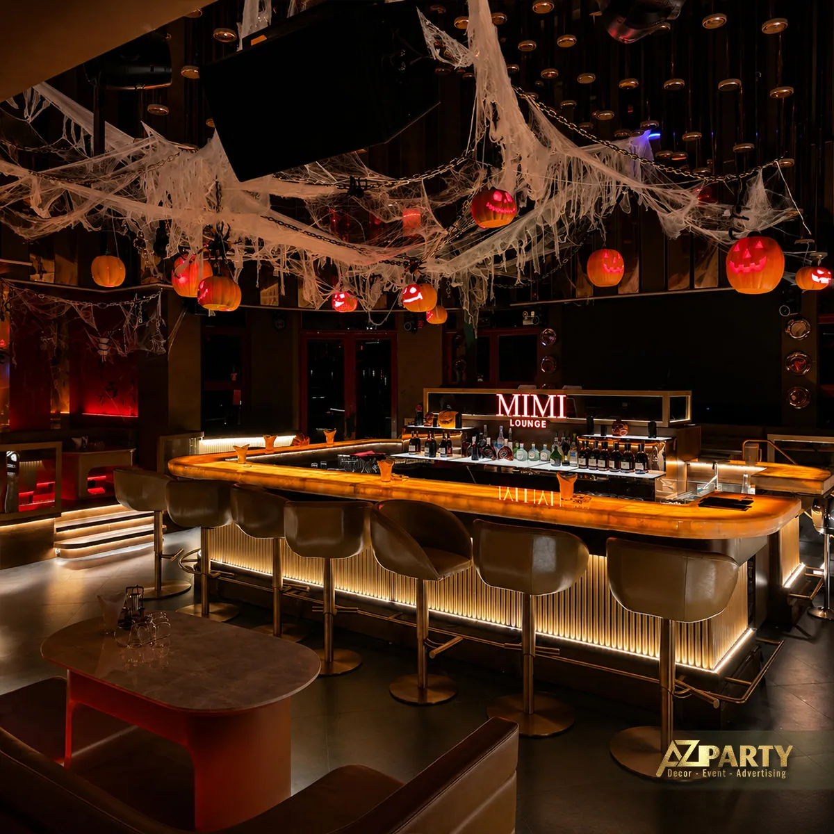 Toàn cảnh quầy bar MIMI LOUNGE với mạng nhện, bí ngô và ánh sáng đỏ cam.
