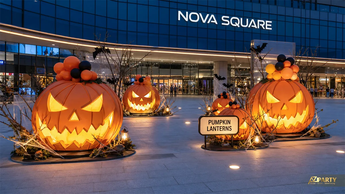 Bốn mô hình bí ngô phát sáng đặt giữa quảng trường, tạo điểm nhấn Halloween khi trời tối