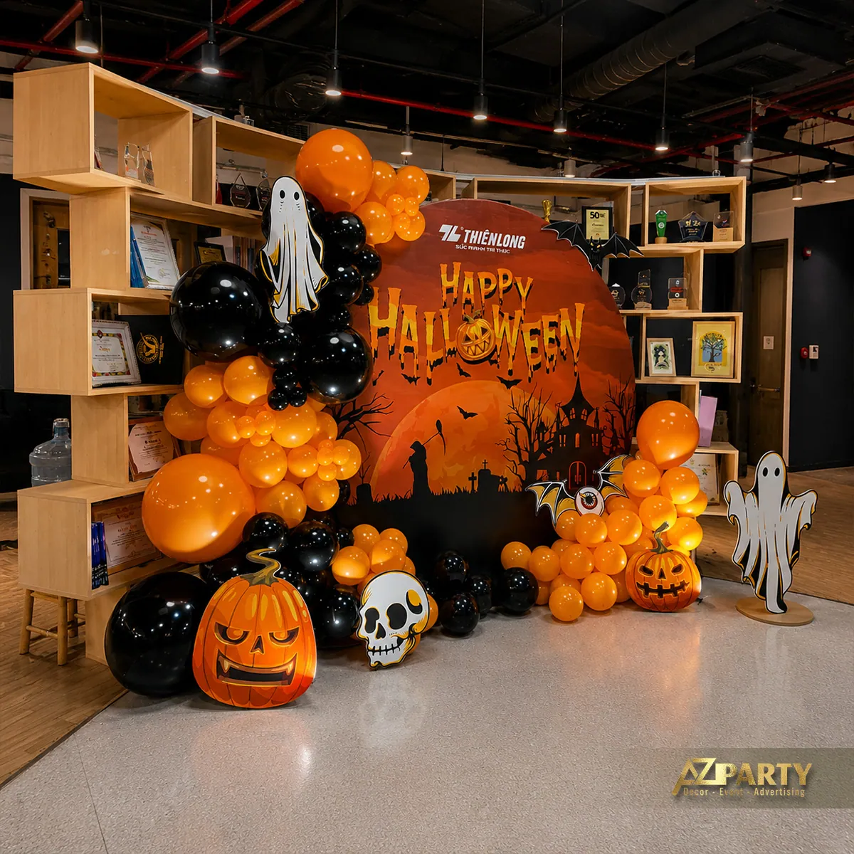 Góc chụp rộng cho thấy toàn bộ cụm bóng bay và phông Halloween đặt trước hệ kệ trưng bày.