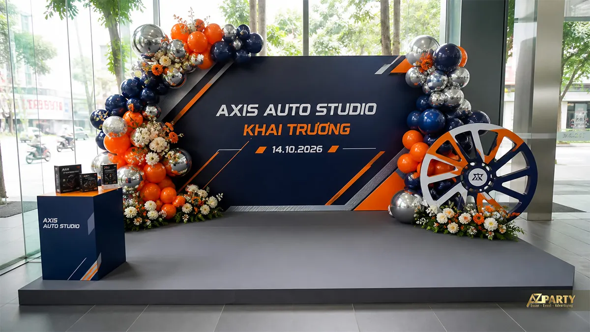 Sân khấu khai trương Axis Auto Studio màu cam đen với họa tiết bánh xe