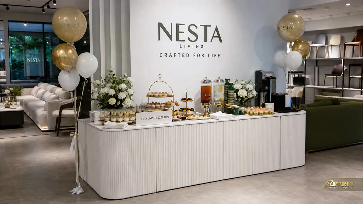 Bàn tiệc Nesta Living màu trắng với bánh ngọt, nước uống, hoa và bóng vàng trắng