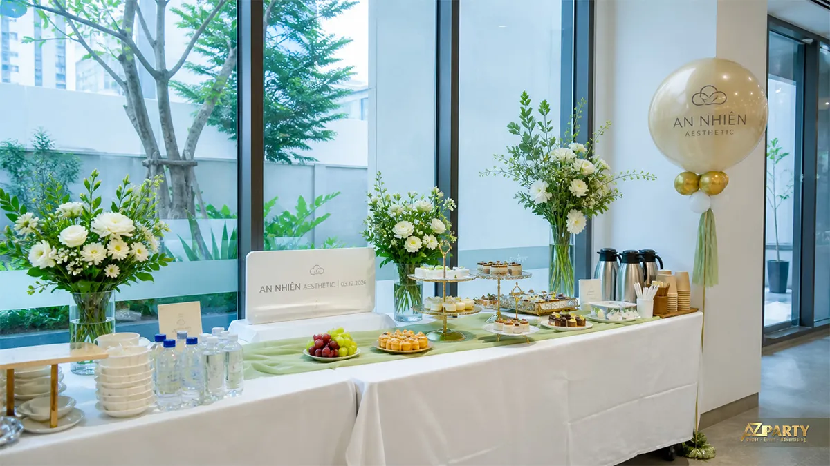 Bàn tiệc An Nhiên Aesthetic cạnh cửa kính với hoa trắng và điểm nhấn xanh lá