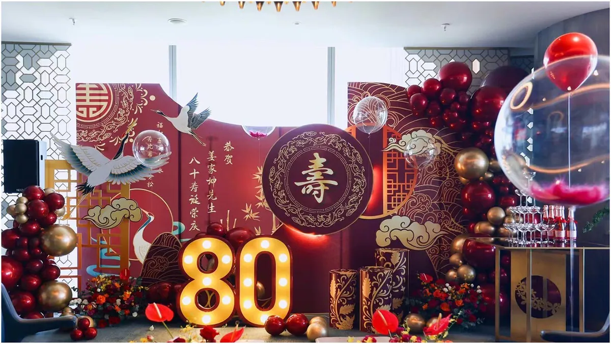 Lễ mừng thọ 80 tuổi của cụ ông họ Khương với số 80 gắn đèn LED nổi bật trước bức bình phong Trung Hoa màu đỏ đô sang trọng.