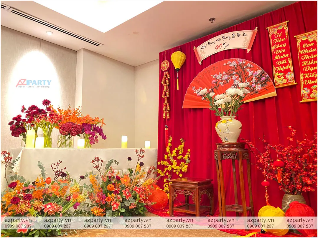 Góc trang trí bàn tiệc với những lọ hoa đầy màu sắc tinh tế dưới ánh đèn ấm áp tại lễ thượng thọ 90 tuổi.
