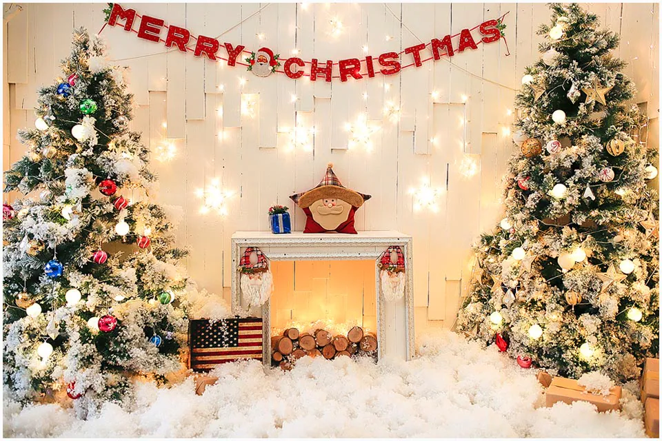 Trang trí giáng sinh phong cách Bắc Âu với mô hình lò sưởi giả ấm áp, hai cây thông Noel phủ tuyết nhân tạo lung linh hai bên và dòng chữ Merry Christmas