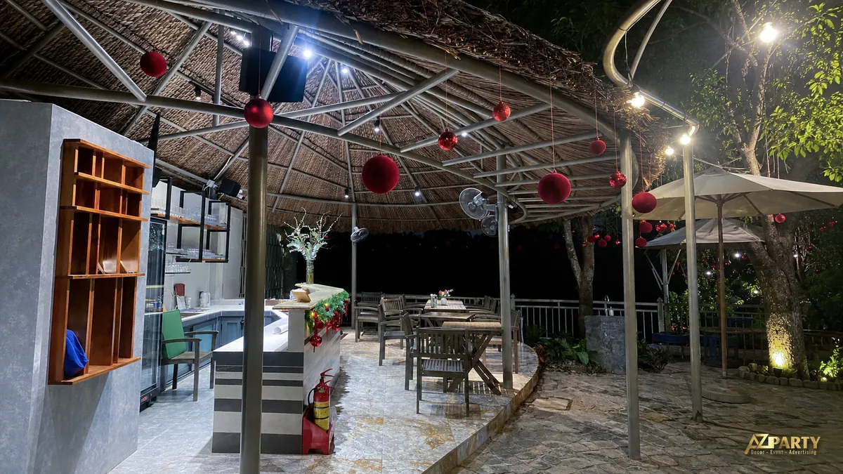 Khu vực bàn ghế ngoài trời dưới mái che trang trí các quả châu đỏ